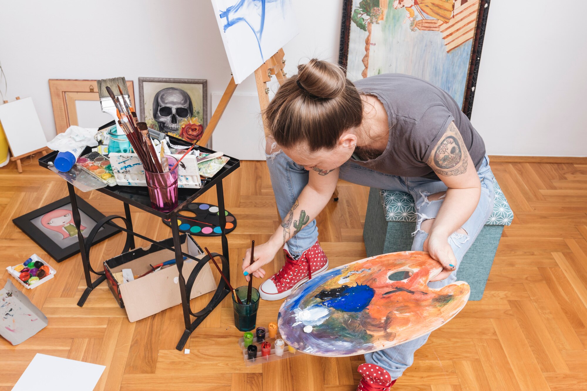 mujer tatuada que sostiene paleta que sumerge brocha agua 23 2148185843